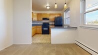 Located at 2555 Old Trevose Rd in Feasterville-Trevose, PA, this two-bedroom, one-bathroom unit offers a well-organized single-floor layout. The combined kitchen and living area forms the heart of the home, with the kitchen showcasing warm honey-toned cabinetry, dark granite-style countertops, a decorative tile backsplash, tile flooring, and black appliances including a gas range and refrigerator. Pendant lighting adds a polished touch above the kitchen peninsula. The living room is generously proportioned, featuring plush wall-to-wall carpeting, baseboard heating, a ceiling fan, a wall-mounted air conditioning unit, and a sliding glass door that opens to a private balcony with outdoor views. Both bedrooms are carpeted and filled with natural light from windows, with the primary bedroom offering a closet and ample floor space. The full bathroom is tiled floor-to-ceiling in warm earth tones, complete with a soaking tub, a vanity with white cabinetry and a dark countertop, and a medicine cabinet above the sink. A connecting hallway ties all rooms together efficiently, completing this functional and comfortable residential layout.