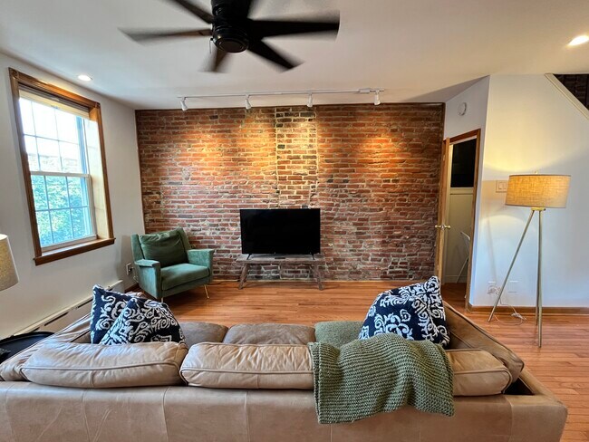 Exposed brick is paired with stylish, modern furnishings. Vizio Smart TV. - 1214 Moore St