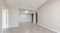 Located at 9550 Long Point Rd in Houston, TX, this single-story unit offers four bedrooms and four bathrooms within a well-organized, efficiently laid-out floor plan. Light-toned ceramic tile flooring runs throughout the entire unit, lending a clean and cohesive look to every room. The living room features vaulted ceilings that enhance the sense of openness, with neutral taupe walls and natural light filtering in through a large window. Each of the four bedrooms is equipped with a ceiling fan and its own window, providing comfortable ventilation and natural light. The primary bedroom includes built-in closet shelving, offering practical storage. The kitchen is a functional standout, featuring gray cabinetry, laminate countertops, a double stainless steel sink, and a warm brick-style tile backsplash that adds character to the space. A dedicated pantry provides additional storage. The four bathrooms include tub-shower combinations, with at least one showcasing floor-to-ceiling gray stone-look tile surround for a polished finish. Each bathroom includes overhead storage and tile flooring. With four closets distributed across the unit, storage is well-addressed throughout. The neutral color palette and consistent finishes give the space a tidy, move-in-ready appearance.