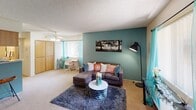 Located at 3040 E Shea Blvd in Phoenix, Arizona, this single-floor residence offers a well-organized layout with distinct living, kitchen, and bathroom areas unified by a consistent teal color palette and warm, neutral tones.

The entryway sets a welcoming tone with carpeted flooring, a wall-mounted mirror above a low storage unit, and a decorative coat rack — providing both function and style upon arrival.

The living area is a comfortable, open space highlighted by a bold teal accent wall that serves as a focal point. Carpeted flooring, a textured ceiling, and a ceiling fan contribute to a relaxed atmosphere. Natural light filters in through a window dressed with teal curtains, and the space flows into a dedicated area ideal for a home office or dining setup.

The galley-style kitchen is efficiently designed with light wood cabinetry lining both sides, ample counter space, a stainless steel sink, and black appliances including a refrigerator, electric range, and microwave. Tile flooring and overhead lighting keep the space bright and practical. Small decorative touches, such as wall-mounted planters, add a personal charm.

The bathroom, visible in the floor plan, features a shower with a curtain enclosure. Throughout the space, the cohesive use of teal accents and warm neutrals creates an inviting and thoughtfully styled environment.
