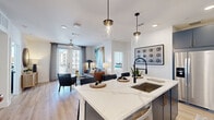 This thoughtfully designed 2-bedroom, 2-bathroom residence in Houston's 77055 corridor offers a seamless blend of modern finishes and functional living. The open-concept kitchen serves as the heart of the home, showcasing bold navy cabinetry with gold hardware, quartz countertops, a subway tile backsplash, stainless steel appliances, and a large center island with pendant lighting — ideal for both cooking and entertaining. The kitchen flows naturally into a bright living room, where light wood-style flooring, a ceiling fan, and French doors with access to the outdoors create an airy, welcoming atmosphere. The primary bedroom is a generous retreat featuring plush carpet, a ceiling fan, and a direct en suite bath appointed with a dual-sink vanity in navy blue, a backlit mirror, white quartz counters, and an elegant marble-style walk-in shower. The second bedroom is equally well-appointed, offering natural light through large windows and its own access to a full bath complete with marble-surround tub and shower. Dedicated closets provide ample storage throughout. Clean white walls and consistent premium finishes tie together the cohesive, contemporary aesthetic of this well-appointed Houston residence.