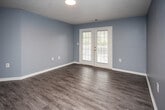 Located at 4013 Peaks Landing Way in Knoxville, Tennessee, this single-floor residence offers a well-organized layout designed for comfortable everyday living. Throughout the home, cool blue-gray walls and crisp white trim create a consistent, calming aesthetic complemented by textured ceilings.

The open living and dining area is finished with warm wood-look luxury vinyl plank flooring and features French doors that invite natural light and provide outdoor access. A pass-through counter connects this space to the kitchen, which is equipped with light wood cabinetry, white appliances including a range and refrigerator, a double-basin sink, and light-colored countertops — all set over matching wood-look flooring.

The bedrooms are carpeted for comfort and each includes a closet with built-in shelving for organized storage. Windows with blinds allow for natural light and outdoor views. One bedroom features a double-door closet configuration, offering generous storage capacity.

The bathroom continues the home's cohesive design with wood-look vinyl flooring, a bathtub, and neutral blue-gray walls. A hallway connects the bedroom and bathroom areas, maintaining a logical and functional flow throughout the residence. Overall, the home presents a clean, move-in-ready environment with practical finishes.