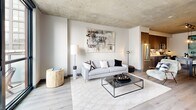 Located in Chicago's vibrant West Loop neighborhood, this one-bedroom, one-bathroom residence at 180 N Ada St delivers a refined industrial-modern aesthetic throughout. Exposed concrete ceilings lend an urban loft character to the open-plan living area, where light wood flooring and neutral tones create a warm, contemporary ambiance. The kitchen is well-appointed with dark flat-panel cabinetry, stainless steel appliances, a decorative tile backsplash, and pendant lighting over a central dining table — seamlessly connecting to the living space. The living room benefits from dramatic floor-to-ceiling windows and a glass-panel door opening directly onto a private balcony, bathing the space in natural light and offering open city views. Track lighting on the concrete ceiling adds a modern industrial touch. The bedroom continues the floor-to-ceiling window theme, with direct balcony access and an exposed concrete ceiling, creating a serene yet urban retreat. A built-in workspace nook off the kitchen provides a functional area for remote work. The bathroom features large-format light tile flooring, dark wood vanity cabinetry, black hardware accents, and a walk-in shower. An in-unit stacked washer and dryer adds everyday convenience.