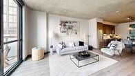 Located in Chicago's vibrant West Loop neighborhood, this one-bedroom, one-bathroom residence at 180 N Ada St delivers a refined industrial-modern aesthetic throughout. Exposed concrete ceilings lend an urban loft character to the open-plan living area, where light wood flooring and neutral tones create a warm, contemporary ambiance. The kitchen is well-appointed with dark flat-panel cabinetry, stainless steel appliances, a decorative tile backsplash, and pendant lighting over a central dining table — seamlessly connecting to the living space. The living room benefits from dramatic floor-to-ceiling windows and a glass-panel door opening directly onto a private balcony, bathing the space in natural light and offering open city views. Track lighting on the concrete ceiling adds a modern industrial touch. The bedroom continues the floor-to-ceiling window theme, with direct balcony access and an exposed concrete ceiling, creating a serene yet urban retreat. A built-in workspace nook off the kitchen provides a functional area for remote work. The bathroom features large-format light tile flooring, dark wood vanity cabinetry, black hardware accents, and a walk-in shower. An in-unit stacked washer and dryer adds everyday convenience.