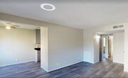 This 570-square-foot apartment offers a blend of functionality and contemporary design. The open-concept layout maximizes the use of space, creating a seamless flow between the living areas. The kitchen showcases sleek gray cabinetry, contrasting beautifully with dark marble-like countertops and stainless steel appliances. Modern wood-look flooring runs throughout the main living areas and kitchen, adding warmth and continuity.

The primary bedroom, measuring 120 square feet, features plush carpeting and a built-in closet, while the second bedroom offers similar amenities. The bathroom is efficiently designed with a combination tub/shower, modern vanity, and coordinating flooring. Large windows in the living room and bedrooms allow ample natural light, brightening the neutral-toned walls.

A sliding glass door in the living area leads to an outdoor space, perfect for enjoying the Las Vegas climate. The apartment's single floor layout and central hallway provide easy access to all rooms. With its updated features and practical design, this apartment offers comfortable living in a compact urban setting.