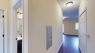 This single-story residence offers a thoughtfully designed layout with a cohesive aesthetic throughout. The open-concept living area is anchored by rich, dark hardwood-style flooring that extends through much of the home, complemented by warm neutral wall tones and crisp white crown molding and baseboards. French doors in the living room invite natural light and provide outdoor access, enhancing the sense of openness in the space.

The kitchen is a functional highlight, featuring dark espresso-toned cabinetry with modern hardware, granite-style countertops, a double-basin sink, and a full suite of stainless steel appliances including a refrigerator, range, and microwave. Recessed lighting and crown molding add a polished finish. An adjacent dining or prep area offers additional counter and cabinet space, with a window providing natural light.

Bedrooms are finished with plush carpet and multiple windows fitted with blinds, ensuring comfort and privacy. The primary bathroom includes a wide vanity with dark cabinetry, a large mirror, and a walk-in shower, while a secondary bathroom offers a tub-shower combo with matching dark cabinetry. A hallway houses the electrical panel, and the layout flows efficiently between all areas of the home.