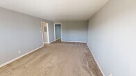 Located at 814 W Hill Ave in Knoxville, TN, this single-floor, 3-bedroom, 1-bathroom unit offers a practical and well-organized layout. The living area is generously sized, featuring neutral gray walls, plush carpeting, and a front entry door flanked by windows that allow natural light to fill the space. The kitchen is efficiently designed with warm wood cabinetry, tile flooring, a built-in sink, and a full suite of black appliances including a refrigerator, dishwasher, and range. An adjacent dining area with tile flooring provides additional functional space. The primary bedroom is notably spacious, offering ample room and direct access to a hallway. The two additional bedrooms are well-proportioned, each featuring carpet flooring, neutral gray walls, individual windows with natural light, and wall-unit HVAC systems. The bathroom is finished with tan tile walls and flooring, featuring a tub-shower combination, a window above the tub for ventilation and natural light, and a decorative tile accent border. Two closets provide convenient storage throughout the unit. The consistent use of neutral tones and carpet throughout the bedrooms creates a cohesive, move-in-ready environment.