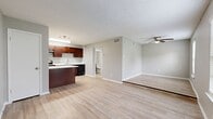 This 420 square foot one-bedroom apartment at Addison Apartments At The Park 1 offers a thoughtful layout maximizing functionality and comfort. The open-concept design seamlessly integrates the kitchen and living areas, creating a spacious feel. The kitchen boasts rich cherry wood cabinetry, contrasting beautifully with light quartz countertops and black appliances. A convenient island provides additional prep space and casual dining options.

The living area features light wood-look flooring and is bathed in natural light from large windows, complete with horizontal blinds. A ceiling fan enhances air circulation and adds a decorative touch. The bedroom continues the airy feel with matching flooring and windows, offering ample space for a comfortable retreat.

The bathroom showcases clean lines with white fixtures, including a shower/tub combination with a sleek chrome showerhead and a modern vanity. Throughout the apartment, neutral wall colors create a blank canvas for personalization. This well-designed space efficiently accommodates all the necessities of comfortable living within its compact footprint.