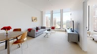 Located on the 12th floor of 800 Main Street in downtown Hartford, Connecticut, this modern high-rise residence offers a thoughtfully designed single-level layout with an open and airy feel throughout. The living room is a standout space, anchored by expansive floor-to-ceiling windows that frame sweeping panoramic views of the Hartford skyline and surrounding cityscape, flooding the room with abundant natural light. Plush carpeting and clean white walls contribute to a bright, contemporary atmosphere. The kitchen is efficiently designed with light wood cabinetry, dark countertops, large-format tile flooring, and stainless steel appliances, providing a functional and stylish cooking space. The primary bedroom is generously proportioned, featuring dramatic corner floor-to-ceiling windows that offer striking views of Hartford's historic architecture, along with soft carpeting and access to a dedicated closet. A second bedroom provides a comfortable, well-lit retreat with its own closet access. The bathroom is finished with large-format dark slate tile flooring, a wall-mounted wood-toned vanity with an integrated sink, and a full tub-shower combination. Throughout the residence, the design maintains a consistent modern aesthetic with clean lines, neutral tones, and quality finishes that reflect refined urban living in the heart of Hartford.