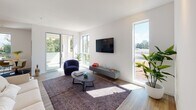 Located on Wilshire Boulevard in the heart of Los Angeles, this modern single-floor residence offers a clean, contemporary design defined by crisp white walls, light wood-style flooring, and an abundance of natural light. The open-concept living area is generously proportioned, featuring large windows and glass doors that frame outdoor views of the surrounding cityscape and tree canopy, creating a bright and airy atmosphere throughout the day. A dedicated dining nook sits adjacent to the living space, highlighted by a marble-top round table and a tall window that draws in natural light. The kitchen is efficiently designed with white shaker cabinetry, dark countertops, and a full suite of stainless steel appliances, including a refrigerator, range, microwave, and dishwasher. A hallway connects the living areas to the private quarters, with two bathrooms serving the residence. One bathroom features a soaking tub and shower combination with white subway tile surround, while the second offers a walk-in shower with matching tile finishes. Both bathrooms include white vanities with integrated sinks and wood-look flooring. The bedroom is well-lit by a tall, narrow window overlooking the street below. Throughout, the space maintains a cohesive, minimalist aesthetic suited to modern urban living.