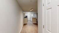 This well-appointed 3-bedroom, 2-bathroom single-floor residence at 6200 Bakers Ferry Rd SW in Atlanta, GA offers a comfortable and functional layout. The open-concept kitchen is a standout feature, showcasing white shaker cabinetry, a classic subway tile backsplash, granite-style countertops, and a full suite of stainless steel appliances including a range, over-the-range microwave, and refrigerator. A peninsula with bar-top seating connects the kitchen seamlessly to the living area, which features wood-look flooring and a ceiling fan, with a door leading to a private outdoor balcony. The three bedrooms are carpeted and well-lit by natural light through large windows with blinds, and each is equipped with a ceiling fan. The spacious primary bedroom includes a dedicated en-suite bathroom and access to a closet. Both bathrooms are finished with clean, white tub-shower combinations and tile surround. A utility room provides additional functional space. Neutral wall tones and textured ceilings are consistent throughout, creating a cohesive and move-in-ready atmosphere across the entire residence.