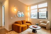 This 420 square foot apartment in Philadelphia offers a modern and efficient living space. The open-concept design maximizes the compact area, seamlessly blending the living room, kitchen, and dining area. The kitchen is a standout feature, boasting sleek white cabinetry, stainless steel appliances, and a mosaic tile backsplash with under-cabinet lighting.

Large windows throughout provide ample natural light and offer impressive city views, creating a sense of spaciousness. The living area is thoughtfully furnished with a mustard yellow sofa and unique lighting fixtures, adding character to the space.

The bathroom showcases a striking design with deep blue tiling and a patterned floor, creating a bold contrast to the apartment's otherwise neutral palette. The bedroom, while compact, features a large window and appears to have built-in storage solutions.

Hardwood flooring runs throughout the apartment, lending warmth and continuity to the space. The entry area includes a digital lock for added security. Despite its small footprint, this apartment efficiently incorporates all essential living areas, making clever use of vertical space with built-in shelving and storage.

The property's location at 1700 N Front St places residents in the heart of Philadelphia, with easy access to urban amenities. This apartment is ideal for those seeking a stylish, low-maintenance living space in a vibrant city setting.