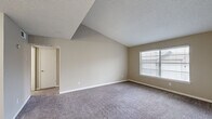 Located at 601 W Renner Rd in Richardson, TX, this one-bedroom, one-bathroom residence offers a thoughtfully organized single-floor layout. The living room features vaulted ceilings with a textured finish, neutral-toned carpet, and a window with blinds that allows natural light to fill the space, creating an open and airy feel.

The kitchen is a standout feature, showcasing granite countertops, white cabinetry, stainless steel appliances including a refrigerator, electric range, and microwave, as well as a double-basin undermount sink. Stylish pendant lighting and a wood-accent backsplash detail add a modern touch. The kitchen opens to the living area via a peninsula counter, enhancing the flow between spaces.

The bedroom is carpeted and well-proportioned, featuring a window that brings in natural light. It includes access to a dedicated walk-in closet equipped with dual hanging rods on both sides, providing ample storage. The bathroom features a full tub-shower combination with tile surround and chrome fixtures.

Throughout the unit, neutral wall tones, white trim, and consistent carpet flooring create a clean and cohesive aesthetic. The overall layout is efficient and functional, making excellent use of the available floor area.