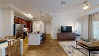 Located at 2098 Seminole Blvd in Largo, Florida, this single-floor residence offers a thoughtfully designed open-concept layout that seamlessly connects the kitchen, dining, and living areas. Rich hardwood-style flooring flows throughout the main living spaces, creating a warm and cohesive aesthetic.

The kitchen is a standout feature, equipped with stainless steel appliances, rich dark wood cabinetry, granite countertops, and a central island with bar seating illuminated by pendant lighting. A dedicated dining area adjacent to the kitchen provides additional space for entertaining. A side-by-side washer and dryer are conveniently situated just off the kitchen.

The living room is generously proportioned, featuring a tray ceiling with accent color, large French doors that invite natural light, and a comfortable, stylish layout. A separate dining nook off the kitchen adds versatility to the floor plan.

The bedrooms offer a calm retreat with plush carpeting and ample space. The bathrooms are well-finished, featuring dark wood vanities with granite countertops, full-size mirrors, and hardwood-style flooring. One bathroom includes a tub-shower combination with classic tile surround, alongside a walk-in closet. The overall ambiance is modern, warm, and livable throughout.