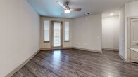 Located at Mira Lago Blvd in Farmers Branch, TX, this thoughtfully designed one-bedroom, one-bathroom residence offers a comfortable and modern living experience across a single floor. The open-concept kitchen and living area serves as the heart of the home, showcasing wood-look plank flooring, a ceiling fan, and large windows that invite natural light. The kitchen is a standout feature, equipped with stainless steel appliances including a range, microwave, and refrigerator, complemented by granite countertops, a subway tile backsplash, and taupe shaker-style cabinetry. A granite-topped center island with pendant lighting provides additional prep and dining space. The carpeted bedroom offers a ceiling fan and multiple windows, creating a bright and restful retreat, along with access to a spacious walk-in closet outfitted with wire shelving systems. The bathroom features wood-look flooring, a tiled soaking tub and shower combination, a granite vanity, and matching cabinetry. A dedicated laundry room with wire shelving adds everyday convenience. Neutral tones and consistent finishes throughout lend the space a cohesive, modern aesthetic.