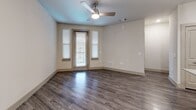 Located at Mira Lago Blvd in Farmers Branch, TX, this thoughtfully designed one-bedroom, one-bathroom residence offers a comfortable and modern living experience across a single floor. The open-concept kitchen and living area serves as the heart of the home, showcasing wood-look plank flooring, a ceiling fan, and large windows that invite natural light. The kitchen is a standout feature, equipped with stainless steel appliances including a range, microwave, and refrigerator, complemented by granite countertops, a subway tile backsplash, and taupe shaker-style cabinetry. A granite-topped center island with pendant lighting provides additional prep and dining space. The carpeted bedroom offers a ceiling fan and multiple windows, creating a bright and restful retreat, along with access to a spacious walk-in closet outfitted with wire shelving systems. The bathroom features wood-look flooring, a tiled soaking tub and shower combination, a granite vanity, and matching cabinetry. A dedicated laundry room with wire shelving adds everyday convenience. Neutral tones and consistent finishes throughout lend the space a cohesive, modern aesthetic.