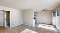 Located at 200 Seneca Street in Merced, California, this single-story, one-bedroom, two-bathroom unit offers a well-designed layout with a clean, modern aesthetic throughout. The open living area greets you with light wood-look vinyl flooring, neutral warm-toned walls, a textured ceiling, and a ceiling fan that enhances air circulation. A wall-mounted heater and natural light streaming through the windows add to the comfort of the space. The living area flows seamlessly into the galley-style kitchen, which is equipped with stainless steel appliances including a range, refrigerator, and dishwasher. Grey cabinetry lines both walls, complemented by light stone-look countertops and recessed lighting overhead, creating a functional and stylish cooking environment. The bedroom offers a comfortable footprint, featuring a window with outdoor views, a wall-unit air conditioner, and direct access to a closet. The bathroom includes a full tub-shower combo, a vanity with ample counter space, and wood-look flooring that ties into the rest of the unit. Two closets provide practical storage solutions throughout. The unit presents a cohesive, freshly updated interior well-suited for comfortable everyday living.