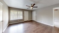 Located at 11111 W Montgomery Rd in Houston, TX, this single-story, 3-bedroom, 2-bathroom home offers a well-organized layout across a comfortable footprint. The open-concept living, dining, and kitchen area serves as the heart of the home, featuring wood-look laminate flooring and ceiling fans throughout. Neutral gray walls create a clean, modern backdrop that flows seamlessly from room to room. The kitchen is well-appointed with gray shaker-style cabinetry, light quartz countertops, a subway tile backsplash, a double stainless steel sink, and black appliances including a range and refrigerator — offering ample storage and counter space. Both bathrooms are finished consistently with gray vanities, quartz countertops, and tub-shower combinations with tile surrounds and wood-look flooring. The three bedrooms are carpeted and each equipped with ceiling fans, with the primary bedroom featuring its own walk-in closet. Additional highlights include four closets total for generous storage, an in-unit laundry area, and a balcony for outdoor enjoyment. The overall aesthetic is clean and updated, presenting a move-in-ready home in a practical, single-level design.