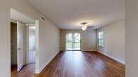 Located along N Military Trail in Boca Raton, Florida, this single-floor residence offers a well-organized layout designed for comfortable everyday living. The main living areas are finished with rich hardwood-style flooring that flows throughout, complemented by neutral wall tones and textured ceilings. Natural light fills the space through sliding glass doors that open to outdoor greenery, as well as multiple windows fitted with blinds throughout the home. The galley-style kitchen is a functional highlight, featuring warm wood cabinetry, granite countertops, a tile floor, mosaic tile backsplash accents, and full appliances including a refrigerator and range. A pass-through counter connects the kitchen to the adjacent living and dining areas. The bedrooms are carpeted for comfort, each offering closet space with built-in shelving and wire rack systems. The bathroom is well-appointed with a granite vanity top, white cabinetry, a large mirror, and a glass-enclosed shower. A dedicated in-unit laundry room provides added convenience, complete with a washer and dryer and overhead wire shelving. Throughout the home, decorative light fixtures add a classic touch, while the open, airy feel of the living spaces makes the layout feel inviting and functional.