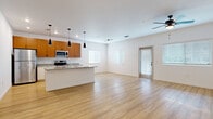 Located at 4500 Lakeland Park Dr in Lakeland, FL, this well-appointed one-bedroom, one-bathroom unit offers a thoughtfully designed single-floor layout that maximizes functionality and comfort. The open-concept living and kitchen area serves as the heart of the home, showcasing light hardwood flooring, crisp white walls, and an abundance of natural light from multiple windows fitted with blinds. A ceiling fan overhead adds to the airy ambiance of the living space.

The kitchen is a standout feature, equipped with warm-toned wood cabinetry, granite countertops, a suite of stainless steel appliances including a refrigerator, range, and microwave, and a spacious island with a built-in sink — ideal for both meal prep and casual dining. Pendant lighting above the island adds a modern, polished touch.

The bedroom offers a comfortable and quiet retreat, carpeted for warmth and featuring a ceiling fan, a window with natural light, and direct access to both a walk-in closet with wire shelving and an in-unit laundry area. The bathroom continues the granite countertop theme with a white vanity, hardwood-style flooring, and a tiled walk-in shower, maintaining a clean and cohesive aesthetic throughout the unit.