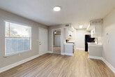 Located at 2880 North Wickham Road in Melbourne, FL, this one-bedroom, one-bathroom unit offers a well-organized, single-floor layout designed for efficient everyday living. The combined kitchen and living room serves as the heart of the home, featuring warm wood-look vinyl flooring, neutral gray walls, and natural light from a window flanked by blinds. The kitchen is outfitted with white shaker-style cabinetry, black hardware, light quartz countertops, a tile backsplash, a stainless steel sink with a modern faucet, and black appliances including a refrigerator and range. A dedicated pantry provides additional storage directly off the kitchen. The living area flows openly from the kitchen, creating a cohesive and functional common space. The bedroom is carpeted for comfort, includes a ceiling fan with light, a sliding-door closet, and a window that brings in natural light. The bathroom and a separate closet add practical storage solutions throughout. A private balcony extends the living space outdoors, offering a spot to enjoy the Florida climate. Clean lines, consistent neutral tones, and updated finishes give the unit a fresh, move-in-ready appearance throughout.
