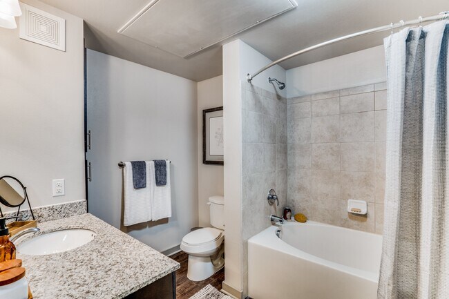 amplio baño con bañera y encimeras de granito - Junction 15