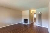 Located at 902 W Remington Dr in Sunnyvale, CA, this single-story 2-bedroom, 1-bathroom home offers a well-organized and functional layout. Rich hardwood-style flooring runs throughout the main living areas, complementing the neutral gray tones on the walls and creating a clean, cohesive aesthetic.

The living room serves as a focal point of the home, featuring a classic white-painted brick fireplace that adds character and warmth. Large windows along the front of the living area invite generous natural light, enhancing the open and airy feel of the space. A ceiling fan in the adjacent dining area provides additional comfort.

The kitchen is efficiently designed with white cabinetry, white appliances including a refrigerator and range, a double-basin sink, and hardwood-style flooring that ties seamlessly into the rest of the home. Ample cabinet storage makes the most of the available space.

The two bedrooms are carpeted in a soft neutral tone, offering a comfortable retreat. Each room benefits from windows that bring in natural light and views of surrounding greenery. With four closets distributed throughout the home, storage is plentiful.

The bathroom is bright and clean, featuring a full tub-shower combination, white vanity with a stone-toned countertop, and hardwood-style flooring consistent with the rest of the home.