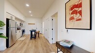 Located at 39 NE Kelly Ave in Gresham, Oregon, this thoughtfully designed one-bedroom, one-bathroom unit offers a modern open-concept layout that maximizes every inch of its efficiently organized floor plan. Light-toned hardwood flooring flows seamlessly throughout, anchoring the bright, clean aesthetic created by crisp white walls and recessed lighting.

The kitchen is a standout feature, outfitted with white shaker cabinetry with matte black hardware, a classic white subway tile backsplash, stainless steel appliances including a refrigerator, range, dishwasher, and microwave, and a sleek single-basin sink. The kitchen opens directly to the living area, creating a connected and functional space ideal for everyday living.

The living room benefits from a large window that frames scenic views of surrounding greenery, filling the space with natural light. The bedroom is a cozy, well-proportioned retreat with its own window and access to a dedicated closet complete with built-in hanging rods. The bathroom features clean, contemporary finishes including a wide vanity with a white countertop, light wood cabinetry, matte black fixtures, and a large mirror. This unit combines modern design and practical living in a compact, well-appointed package.