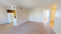 Located at 2310 70th St in Lubbock, Texas, this single-floor home offers a practical and functional layout across its well-organized living spaces. The open living area is finished with neutral-toned carpet and light-colored walls, creating a clean and welcoming atmosphere. A textured ceiling runs throughout the home, adding a consistent design element to each room. The kitchen is outfitted with dark wood cabinetry offering ample storage, light countertops, tile flooring, a double-basin sink, a dishwasher, and a range, making it a fully equipped space for everyday cooking. The living room connects seamlessly to additional rooms and features a sliding glass door with vertical blinds leading to an outdoor area, alongside a window that brings in natural light. The bedrooms are carpeted and generously sized, each featuring windows with blinds for natural light and privacy. The primary bedroom includes a ceiling fan with light fixture and access to a dedicated closet. The bathroom is equipped with a full tub-shower combination, a single vanity, and tile flooring. Throughout the home, neutral tones and functional finishes contribute to a straightforward, move-in-ready environment suited for comfortable everyday living.