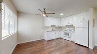 Located at 9012 Casals St in Sacramento, California, this efficiently designed single-floor unit makes smart use of its compact footprint. Rich, dark hardwood-style flooring runs throughout the space, lending warmth and visual continuity to every room.

The open-concept kitchen and living area form the heart of the unit. The kitchen is outfitted with crisp white cabinetry extending from floor to ceiling, light countertops, a double-basin sink, an electric range with overhead ventilation, and a full-size refrigerator. A ceiling fan with integrated lighting anchors the combined living space, promoting airflow and comfort. A wall-mounted HVAC unit and a window overlooking the exterior complete the living area.

The unit includes two bathrooms. One features a soaking bathtub with white subway tile surround, while the other is a more functional space that incorporates an in-unit washer and a vessel sink set atop a white vanity with stone-look countertops and a large mirror. A dedicated closet with a hanging rod provides organized storage.

The clean, neutral color palette of white walls and bright finishes throughout creates a light, airy atmosphere, making the space feel open and easy to personalize.
