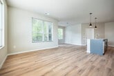 Located at 3005 University Ave in Madison, WI, this well-appointed 2-bedroom, 2-bathroom unit offers a thoughtfully designed layout across its main living floor. The open-concept kitchen and living area serves as the heart of the home, showcasing granite countertop surfaces, crisp white cabinetry, stainless steel appliances, and stylish pendant lighting. Light-toned hardwood flooring flows throughout the kitchen, living room, and hallway, creating a bright, cohesive feel. Large windows in the living room invite abundant natural light and offer views of the surrounding neighborhood's mature tree canopy. A private balcony extends the living space outdoors, providing a pleasant outdoor retreat with lush green views. Both bedrooms are carpeted for comfort, each featuring windows with blinds that frame natural scenery. The primary bedroom includes access to a dedicated bathroom with a granite-topped vanity, walk-in closet with built-in shelving, and modern black hardware accents. The second bathroom features a full tub-shower combination with chrome fixtures. A central hallway connects all rooms efficiently, and two closets provide ample storage throughout the unit. The overall aesthetic is clean, contemporary, and move-in ready.