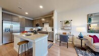 This single-story, one-bedroom, one-bathroom residence offers a thoughtfully designed open-concept layout that maximizes its comfortable footprint. The kitchen serves as the heart of the home, showcasing rich dark-toned cabinetry, a classic white subway tile backsplash, granite countertops, and a full suite of stainless steel appliances including a refrigerator, range, microwave, and dishwasher. A central island with a granite surface provides additional prep space and bar seating, seamlessly connecting the kitchen to the living and dining areas. Light wood-tone flooring runs throughout, lending warmth and visual continuity across the entire space. The living room is bright and welcoming, featuring multiple windows with natural light and a ceiling fan overhead. The bedroom is generously sized, offering a ceiling fan, windows with outdoor views, and direct access to a spacious walk-in closet equipped with wire shelving systems for ample storage. The bathroom features a granite-topped double vanity with stylish cabinetry and a shower-tub combination. Neutral wall tones and recessed lighting throughout the home create a clean, modern ambiance well-suited for comfortable everyday living.
