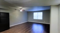 Located at 5026 Dierker Road in Columbus, Ohio, this single-floor space offers a clean, straightforward layout designed for comfortable everyday living. The main living area is a standout feature, showcasing rich, dark hardwood flooring that runs throughout and contrasts elegantly with the cool, neutral gray walls. White baseboards provide a crisp finishing detail that ties the room together visually.

A ceiling fan with an integrated light fixture is centrally mounted, ensuring year-round air circulation and supplemental lighting. A large window allows natural light to pour into the space, brightening the interior and creating an open, airy feel. The textured ceiling adds a subtle traditional character to the room.

The overall ambiance of the space is calm and understated, with a neutral color palette that provides a versatile backdrop suitable for a variety of interior styles and furnishings. The single-floor layout offers practical, accessible living without the need to navigate stairs. The combination of durable flooring, functional fixtures, and ample natural light makes this space a functional and inviting environment in the Columbus, OH area.