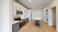 Step into a life of modern elegance in Charlotte's vibrant community. The sleek kitchen dazzles with stainless steel appliances, crisp white cabinetry, dark lower cabinets, subway tile backsplash, and a center island — perfect for inspired cooking and entertaining. Warm luxury vinyl plank flooring flows throughout, uniting each space effortlessly. The sun-drenched bedroom features a ceiling fan and a bright window framing outdoor views, creating a serene retreat. The spa-inspired bathroom stuns with bold navy subway tile, a soaking tub, and sophisticated dark fixtures. This is Charlotte living elevated.