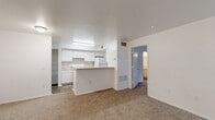 Located at 2074 Midyette Rd in Tallahassee, FL, this single-floor residence offers a practical and well-organized layout with two bedrooms and two bathrooms. The open-concept living and dining area is finished with plush carpeting and flows seamlessly toward a windowed wall fitted with vertical blinds, allowing natural light to fill the space. A ceiling fan anchors the living area, adding both function and comfort. The kitchen features white cabinetry, open shelving, white appliances, and a peninsula counter that serves as a natural divider between the kitchen and living areas. Durable hardwood-style flooring runs through the kitchen and entry zones, complementing the neutral, light-filled interior. The primary bedroom is a comfortable, carpeted retreat with access to a dedicated closet space outfitted with wire shelving and hanging rods — offering generous storage on hardwood-style flooring. The bathrooms are clean and functional, with one featuring a full tub-shower combination finished in classic white subway tile. A second closet provides additional storage throughout the home. The overall aesthetic is clean and neutral, with white walls throughout, making the space easy to personalize.