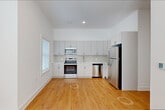 Located at 115 Main Street in Lincoln Park, NJ, this well-appointed 2-bedroom, 1-bathroom residence offers a thoughtfully designed single-floor layout with modern finishes throughout. Warm hardwood-style flooring flows seamlessly through every room, complemented by crisp white walls and clean baseboards that create a bright, cohesive aesthetic.

The open-concept kitchen and living area serves as the heart of the home. The kitchen is outfitted with sleek gray cabinetry extending to the ceiling for ample storage, white quartz-style countertops, a hexagonal tile backsplash, and a full suite of stainless steel appliances including a refrigerator, dishwasher, electric range, and microwave.

A well-lit hallway with recessed lighting connects the bedrooms and additional spaces, with a dedicated electrical panel conveniently accessible. Both bedrooms feature natural light through sizable windows with blinds and individual wall-mounted HVAC units for climate control. The primary bedroom is a comfortable size, while the second bedroom offers flexible use. Three closets throughout the unit provide generous storage.

The bathroom features a walk-in glass-enclosed shower with large-format neutral tile and a clean, minimalist design. A dedicated laundry room houses a stacked washer and dryer, adding everyday convenience to this well-equipped residence.
