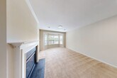 Located at Charley's Place in Bay Shore, NY, this one-bedroom, one-bathroom unit offers a well-organized layout across a single floor. The combined living and dining area is a highlight of the home, featuring warm neutral-toned carpet, crown molding, and a classic white-mantled fireplace with a glass-front insert. A charming bay window floods the space with natural light and provides views of the surrounding greenery, creating an inviting and airy atmosphere.

The kitchen is equipped with rich cherry wood cabinetry, dark countertops, and stainless steel appliances including a gas range and refrigerator. A peninsula with a built-in sink adds functional counter space and connects the kitchen to the main living area, which features light hardwood-style flooring for easy maintenance.

The spacious primary bedroom offers generous proportions, plush carpeting, and two windows that bring in ample natural light with views of lush trees. A dedicated closet provides practical storage. The bathroom is clean and well-appointed, featuring tile flooring, a wood vanity with a white countertop, a toilet, and a walk-in shower with sliding glass doors. A utility room rounds out the functional spaces within this comfortable and efficiently designed home.
