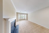 Located at Charley's Place in Bay Shore, NY, this one-bedroom, one-bathroom unit offers a well-organized layout across a single floor. The combined living and dining area is a highlight of the home, featuring warm neutral-toned carpet, crown molding, and a classic white-mantled fireplace with a glass-front insert. A charming bay window floods the space with natural light and provides views of the surrounding greenery, creating an inviting and airy atmosphere.

The kitchen is equipped with rich cherry wood cabinetry, dark countertops, and stainless steel appliances including a gas range and refrigerator. A peninsula with a built-in sink adds functional counter space and connects the kitchen to the main living area, which features light hardwood-style flooring for easy maintenance.

The spacious primary bedroom offers generous proportions, plush carpeting, and two windows that bring in ample natural light with views of lush trees. A dedicated closet provides practical storage. The bathroom is clean and well-appointed, featuring tile flooring, a wood vanity with a white countertop, a toilet, and a walk-in shower with sliding glass doors. A utility room rounds out the functional spaces within this comfortable and efficiently designed home.
