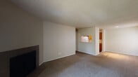 Located at 3165 Woodland Hills Dr in Colorado Springs, Colorado, this single-floor residence offers a well-organized layout designed for comfortable everyday living. The expansive living room serves as the heart of the home, featuring plush wall-to-wall carpeting, a textured ceiling, and a fireplace that anchors the space. A convenient pass-through window connects the living area to the kitchen, creating an open, communicative feel between the two spaces. The kitchen is efficiently designed in a galley configuration, outfitted with warm wood-toned cabinetry, white appliances including a refrigerator, range, microwave, and dishwasher, and durable wood-look flooring. A closet within the kitchen provides additional storage. The bedrooms are generously sized, each with plush carpeting, ceiling fans, and windows that invite natural light and views of the surrounding greenery. A sliding glass door in one area leads to an outdoor space, further enhancing the connection to the outdoors. The bathrooms feature wood-look flooring, warm wood vanity cabinetry with light stone-style countertops, and a full tub-shower combination with white tile surround. Throughout the residence, neutral tones and textured ceilings create a clean, cohesive aesthetic.