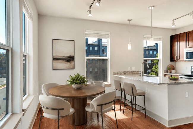 Una cocina moderna con mesa de comedor y sillas. - ICON at Dulles