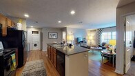 Located on Ashton Lane in Kent, Ohio, this single-floor residence offers a well-organized, open-concept layout that efficiently connects the kitchen, dining, and living areas. The kitchen serves as a central hub, featuring a large island with dark granite countertops, warm-toned wood cabinetry, black appliances including a refrigerator and range, and recessed lighting overhead. The island provides both workspace and bar seating, creating a natural transition into the open living area. Hardwood-style flooring runs throughout the main living spaces, lending a cohesive, clean aesthetic.

The living room benefits from a large window that introduces natural light and features a textured ceiling and a bold accent wall. A dedicated in-unit stacked washer and dryer is conveniently accessible from the main living area. The hallway connects to multiple bedrooms, each carpeted and equipped with closets offering organized storage. The bedrooms include windows for natural light, and accent walls give each room a distinct character.

Two full bathrooms serve the unit, each finished with tile flooring, a tub-shower combination, a vanity with granite countertops, and wood cabinetry, providing functional and consistent finishes throughout.