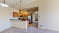 Located at 1133 N Grape Dr in Moses Lake, WA, this single-floor residence offers two bedrooms and two bathrooms within a well-utilized floor plan. The kitchen is a standout feature, equipped with stainless steel appliances including a refrigerator, gas range, and microwave. Warm wood cabinetry, granite-style countertops, a breakfast bar, and stylish pendant lighting give the space a polished, functional character. Track lighting and an open layout connect the kitchen seamlessly to the living area, which features plush carpeting and a sliding glass door that opens to a private balcony with outdoor views.

The primary bedroom benefits from vaulted ceilings, multiple windows that invite natural light, and a sliding closet for convenient storage. The second bedroom is similarly carpeted and bright, with a large window overlooking the surroundings. Both bathrooms are finished with wood-toned cabinetry, granite-style countertops, and light hardwood-style flooring. One bathroom includes a full tub-shower combination, while the other features a vanity with a large mirror and towel bar. Neutral tones and clean finishes throughout lend the space a calm, move-in-ready ambiance.