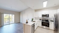 Located in Murrieta, CA, this well-appointed 3-bedroom, 2-bathroom single-story residence offers a bright and modern living experience. The open-concept layout seamlessly connects the kitchen, dining, and living areas, creating an inviting communal space bathed in natural light from skylights and large windows. The kitchen is thoughtfully designed with crisp white shaker cabinetry, a hexagonal tile backsplash, a peninsula with an undermount sink, and stainless steel appliances including a refrigerator, range, and over-the-range microwave. Light wood-style flooring flows throughout the main living areas, complemented by vaulted ceilings that lend an airy sense of openness. The living room opens to a private balcony through sliding glass doors, offering outdoor views of the surrounding neighborhood. The three bedrooms are carpeted for comfort, each with generous closet space — including a spacious walk-in closet with built-in shelving and hanging rods. The primary bedroom features mirrored sliding closet doors and direct access to an adjacent room. Two full bathrooms are finished with light flooring, white vanities, and tub-shower combinations. A ceiling fan in the living area and abundant storage throughout — including five total closets — round out this thoughtfully designed home.