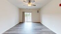 Located at 110 Bulmer Loop in Winchester, VA, this well-appointed 2-bedroom, 2-bathroom unit offers a thoughtfully designed single-floor layout with modern finishes throughout. The open-concept kitchen and living area serves as the heart of the home, where a granite-topped island anchors the space and flows seamlessly into the living room. The kitchen is equipped with stainless steel appliances—including a refrigerator, range, microwave, and dishwasher—complemented by gray shaker-style cabinetry, granite countertops, and a stainless steel sink. Wood-style flooring runs throughout, adding warmth and continuity. The living room features a ceiling fan and is brightened by natural light from a sliding glass door that opens to a private balcony with outdoor views. Both bedrooms are comfortably sized, including a generously proportioned primary bedroom, each featuring ceiling fans and wood-style flooring. The two bathrooms are finished with gray vanity cabinetry, white countertops, and a shower-tub combination. Ample storage is provided through two well-sized closets outfitted with wire shelving systems, maximizing organizational capacity. The overall ambiance is clean, bright, and move-in ready.