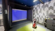 This 770 square foot space in Little Rock, Arkansas, is a cutting-edge golf simulator lounge that seamlessly blends industrial and contemporary design elements. The single-floor layout maximizes functionality and style, featuring a striking blue ceiling that adds depth and drama to the room.

The lounge's focal point is a large glass garage door that floods the space with natural light and offers views of the surrounding area. This unique feature creates an indoor-outdoor feel and can be opened to extend the living space. The main area is furnished with comfortable cream-colored sofas accented by vibrant yellow throw pillows, creating a inviting seating arrangement.

A state-of-the-art golf simulator dominates one wall, complete with a large projection screen and high-tech equipment. The space is further enhanced by multiple flatscreen TVs, ensuring guests can enjoy various entertainment options. The industrial-chic aesthetic is reinforced by exposed ductwork, track lighting, and a textured accent wall with a geometric pattern.

The lounge also includes a sleek bar area with pendant lighting and modern stools, perfect for post-game refreshments. Thoughtful details like a stylish area rug, decorative accessories, and carefully chosen artwork complete the sophisticated ambiance of this unique recreational space.