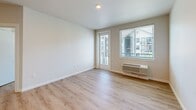 Located at 917 SW 31st St in Battle Ground, WA, this thoughtfully designed 2-bedroom, 2-bathroom apartment offers a clean, contemporary aesthetic across a well-organized single-floor layout. Light hardwood flooring flows consistently throughout the space, complementing the bright white walls and modern finishes.

The open-concept kitchen serves as a central hub, featuring rich walnut-toned cabinetry, white quartz countertops, a subway tile backsplash, and a full suite of stainless steel appliances including a refrigerator, range, microwave, and dishwasher. A kitchen island provides additional prep and dining space, while recessed lighting adds a polished touch.

The living area is bathed in natural light through large windows fitted with blinds, and a glass door leads to an outdoor balcony, enhancing the sense of openness. Both bedrooms are comfortably sized with light hardwood floors, ceiling fans, and windows offering neighborhood views. The primary bedroom is generously proportioned and includes its own dedicated bathroom.

Both bathrooms are finished with walnut-toned vanities, white quartz countertops, and large mirrors. A walk-in closet provides practical storage. The unit also includes in-unit climate control units in key rooms, ensuring year-round comfort.