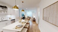 Located at 6107 Decker Ln in Austin, TX, this well-designed 2-bedroom, 3-bathroom home offers a thoughtfully planned single-floor layout with clean, modern finishes throughout. The open-concept living and dining area is anchored by warm wood-look flooring, crisp white walls, and generous natural light filtering through sheer-curtained windows. A ceiling fan adds comfort to the inviting living room, which flows seamlessly toward the dining space adorned with elegant gold pendant lighting overhead. The kitchen is outfitted with white shaker cabinetry, stainless steel appliances, white quartz countertops, a subway tile backsplash, and open shelving — combining style with functionality. The primary bedroom is a comfortable retreat featuring a ceiling fan, large windows with sheer curtains, and plush carpeting. Its en-suite bathroom offers a wide vanity with ample counter space and leads directly to a walk-in closet with built-in shelving and hanging rods. The second bedroom is equally bright, with natural light and carpet flooring. Three full bathrooms — including one with a soaking tub — ensure convenience for residents and guests alike. Two dedicated closets provide practical storage throughout this well-appointed Austin home.