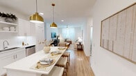 Located at 6107 Decker Ln in Austin, TX, this well-designed 2-bedroom, 3-bathroom home offers a thoughtfully planned single-floor layout with clean, modern finishes throughout. The open-concept living and dining area is anchored by warm wood-look flooring, crisp white walls, and generous natural light filtering through sheer-curtained windows. A ceiling fan adds comfort to the inviting living room, which flows seamlessly toward the dining space adorned with elegant gold pendant lighting overhead. The kitchen is outfitted with white shaker cabinetry, stainless steel appliances, white quartz countertops, a subway tile backsplash, and open shelving — combining style with functionality. The primary bedroom is a comfortable retreat featuring a ceiling fan, large windows with sheer curtains, and plush carpeting. Its en-suite bathroom offers a wide vanity with ample counter space and leads directly to a walk-in closet with built-in shelving and hanging rods. The second bedroom is equally bright, with natural light and carpet flooring. Three full bathrooms — including one with a soaking tub — ensure convenience for residents and guests alike. Two dedicated closets provide practical storage throughout this well-appointed Austin home.