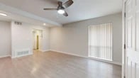 This thoughtfully laid-out 1-bedroom, 1-bathroom unit offers a clean, modern aesthetic with consistent light wood-toned flooring flowing throughout every room. The open living area is bright and airy, featuring a ceiling fan with integrated lighting, recessed lights, and large vertical-blind-covered windows and a sliding door that allow generous natural light to fill the space. Neutral gray-toned walls provide a versatile backdrop throughout. The kitchen is well-appointed with white shaker-style cabinetry, a classic white subway tile backsplash, stainless steel appliances including a refrigerator, electric range, over-the-range microwave, and dishwasher, plus a stainless steel sink. The bedroom offers a comfortable footprint with multiple windows dressed in horizontal blinds, providing ample natural light and views of surrounding greenery. The bathroom features a full soaking tub and shower combination with elegant large-format marble-look tile surround and chrome fixtures. Additional conveniences include a hallway, a dedicated closet for storage, and a well-connected layout that maximizes efficient use of the available space. Overall, the unit presents a clean, contemporary feel ideal for comfortable everyday living.