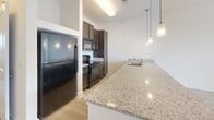 Located in the South Junction neighborhood of Memphis, Tennessee, this single-floor residence offers a thoughtfully designed layout with a clean, contemporary aesthetic throughout. The kitchen serves as a standout feature, showcasing an expansive granite countertop island with a built-in sink, rich dark-stained cabinetry, and black appliances including a refrigerator, electric range, and built-in microwave. Pendant lighting above the island adds a polished finishing touch, while the space flows seamlessly into an open living area finished with light wood-style flooring that extends naturally throughout the common spaces.

The living area is bright and open, benefiting from natural light and direct access to an outdoor area. Bedrooms feature plush carpeting and ceiling fans, with windows fitted with blinds that frame views of the surrounding neighborhood. The primary bedroom includes access to a walk-in closet outfitted with wire shelving, as well as an en-suite bathroom featuring dark wood vanity cabinetry, a single sink with a large mirror, and a full tub-shower combination set on light wood-style flooring. The overall palette of neutral whites and warm tones creates a calm, cohesive ambiance throughout the residence.